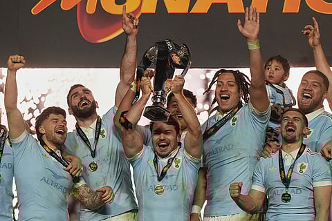 Antoine Dupont of France holds the trophy aloft after clinching the title after winning the Six Nations rugby union match between France and England in Saint-Denis, outside Paris.