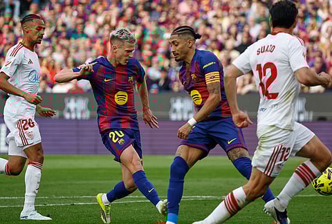 Barcelona's Dani Olmo, second left, scores his side's third goal during the Spanish La Liga soccer match between Barcelona and Sevilla in Barcelona, Spain.