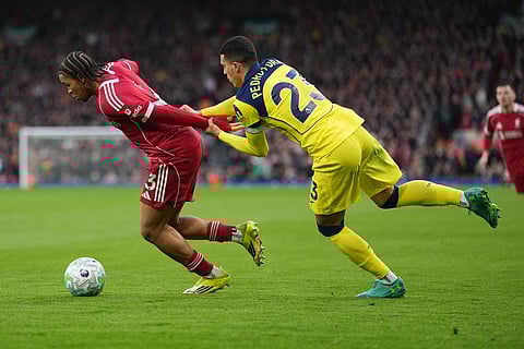 Tottenham's Pedro Porro holds Liverpool's Rio Ngumoha during the Premier League soccer match between Liverpool and Tottenham in Liverpool, England.