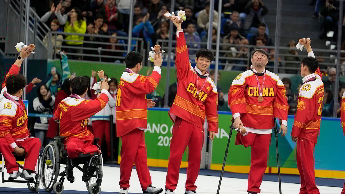 China players celebrate on the podium after winning the bronze medal at the end of the ice hockey at the 2026 Winter Paralympics, in Milan, Italy, Sunday, March 15, 2026. - (AP Photo/Luca Bruno)