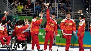 (AP Photo/Luca Bruno) : China players celebrate on the podium after winning the bronze medal at the end of the ice hockey at the 2026 Winter Paralympics, in Milan, Italy, Sunday, March 15, 2026.
