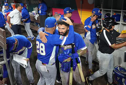 Venezuela's bench coach Robinson Chirinos, left, and Gleyber Torres, right, celebrate their victory over Japan after a World Baseball Classic quarterfinal game, in Miami.