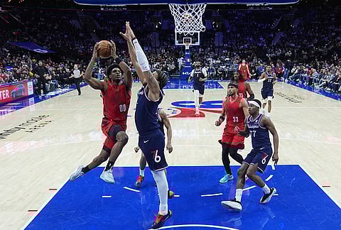 Portland Trail Blazers' Scoot Henderson (00) goes up to shoot against Philadelphia 76ers' Trendon Watford, center, during the second half of an NBA basketball game in Philadelphia.
