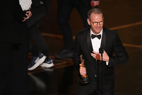Joachim Trier accepts the award for international feature film for "Sentimental Value" during the Oscars at the Dolby Theatre in Los Angeles.