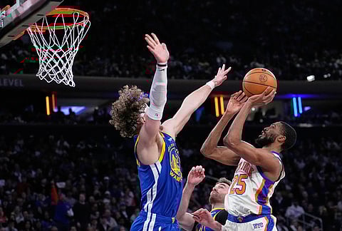 New York Knicks' Mikal Bridges, right, puts up a shot over Golden State Warriors' Brandin Podziemski, left, during the second half of an NBA basketball game in New York.