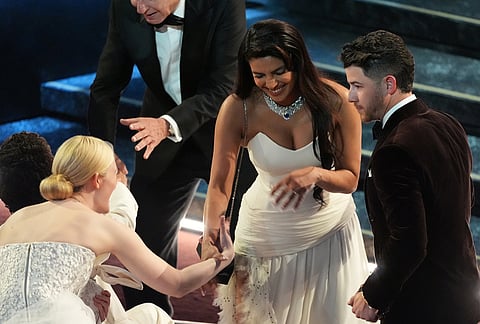 Elle Fanning, from left, Priyanka Chopra Jonas, and Nick Jonas in the audience during the Oscars at the Dolby Theatre in Los Angeles.