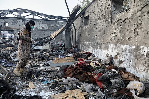 Taliban rescue team member Allah Mohammad Farooq inspects the site of a late-Monday airstrike at a drug rehabilitation hospital in Kabul, Afghanistan.