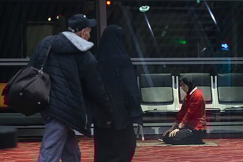Members of Iran's women's football team pray at the Kuala Lumpur International Airport in Sepang, Malaysia.