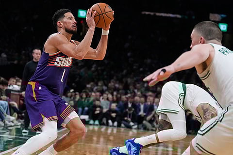 Phoenix Suns guard Devin Booker (1) looks to shoot against the Boston Celtics during the second half of an NBA basketball game in Boston.