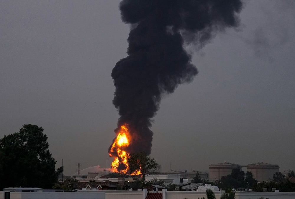 Fire and plumes of smoke rises after a drone struck a fuel tank forcing the temporary suspension of flights. near Dubai International Airport, in United Arab Emirates, early Monday, March 16, 2026. 
 - | Photo: AP