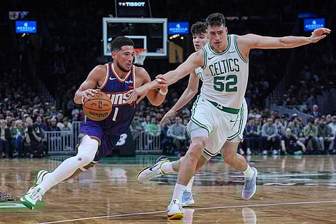 Phoenix Suns guard Devin Booker (1) drives to the basket against Boston Celtics center Luka Garza (52) during the second half of an NBA basketball game in Boston.