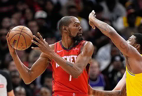 Houston Rockets' Kevin Durant (7) is defended by Los Angeles Lakers' Marcus Smart during the first half of an NBA basketball game in Houston.
