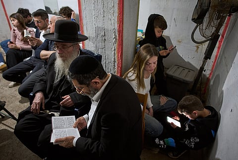 People take cover in an underground bomb shelter as air raid sirens warn of incoming Iranian missile strike, in Ramat Gan, Israel, Wednesday, March 11, 2026. 