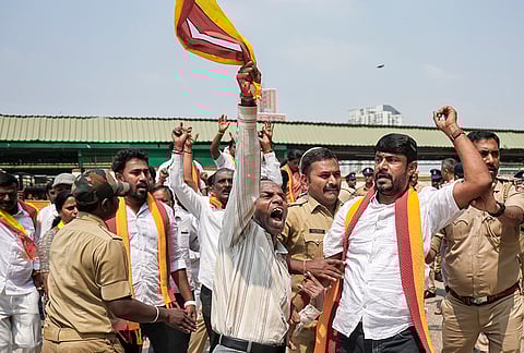 Police personnel detain Karnataka Rakshana Vedike members during a protest against the exclusion of Kannada in railway recruitment exams, at Krantiveera Sangolli Rayanna Railway Station, in Bengaluru.