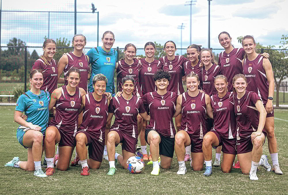 Iranian soccer player's Fatemeh Pasandideh, fourth from right at front row, and Atefeh Ramezanisadeh, fourth from left at front row, pose for a photo with the Brisbane Roar women's A-League team at a training session in Brisbane, Australia. - | Photo: Brisbane Roar via AP