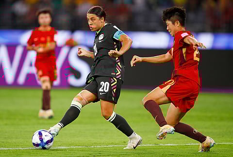 Australia's Sam Kerr passes the ball as China's Zhang Chengxue, right, watches during the Women's Asian Cup semifinal soccer match between China and Australia in Perth, Australia.