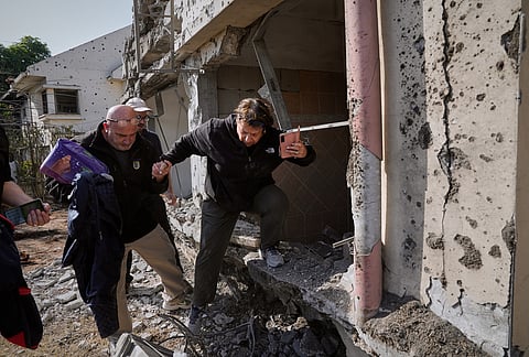 A woman gathers belongings from her family's home after it was damaged by a projectile launched from Lebanon, in Haniel, central Israel, Thursday, March 12, 2026.