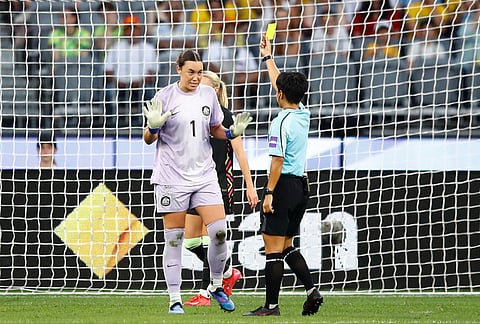 Australia's goalkeeper Mackenzie Arnold, left, reacts as she receives a yellow card from referee Supiree Testhomy during the Women's Asian Cup semifinal soccer match between China and Australia in Perth, Australia.