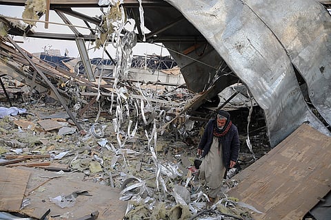 A rescue worker inspects the site of a late-Monday airstrike at a drug rehabilitation hospital in Kabul, Afghanistan.
