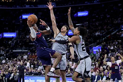 Los Angeles Clippers guard Bennedict Mathurin, left, shoots against San Antonio Spurs guard Carter Bryant, center, and guard Devin Vassell during the second half of an NBA basketball game in Inglewood, Calif.