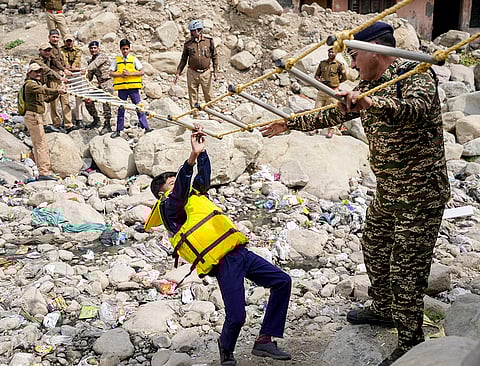 A child takes part in a mock drill as part of a district-wide disaster management exercise, at Kalsiya Bridge, in Haldwani, Nainital district, Uttarakhand.
