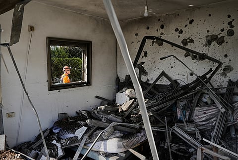 Israeli authorities inspect homes damaged by a projectile launched from Lebanon, in Haniel, central Israel, Thursday, March 12, 2026. 