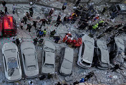 Rescue workers gather at the site where Israeli airstrikes hit apartments in Beirut, Lebanon, Wednesday, March 11, 2026. 