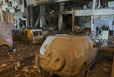 People inspect the site of a destroyed branch of Al-Qard Al-Hassan, a non-bank financial institution run by Hezbollah, which was hit by an Israeli airstrike in central Beirut, Thursday, March 12, 2026.