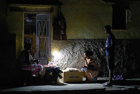 Street vendors chat during a blackout in Havana, Monday, March 16, 2026. 