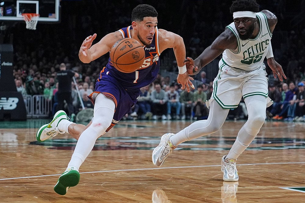 Phoenix Suns guard Devin Booker (1) drives to the basket against Boston Celtics center Neemias Queta, right, during the second half of an NBA basketball game in Boston. - | Photo: AP/Charles Krupa