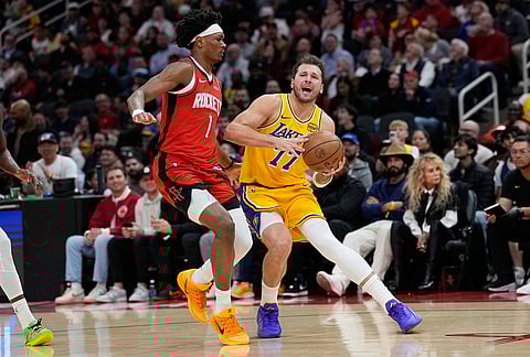 Los Angeles Lakers' Luka Doncic (77) is guarded by Houston Rockets' Amen Thompson (1) during the first half of an NBA basketball game in Houston.