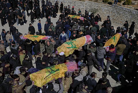 Mourners carry the bodies of Hezbollah fighters who were killed by Israeli airstrikes during their funeral procession in Khraibeh village, eastern Lebanon, Sunday, March 8, 2026. 