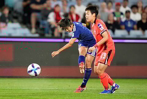Japan's Riko Ueki, left, takes a shot at goal as South Korea's Noh Jin-young during the Women's Asian Cup semifinal soccer match between Japan and South Korea in Sydney.