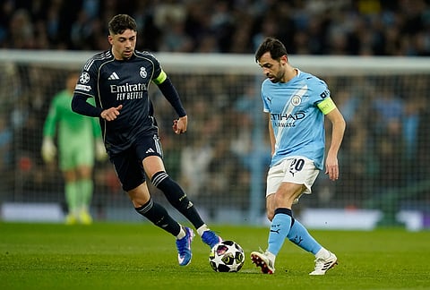 Manchester City's Bernardo Silva and Real Madrid's Federico Valverde challenge for the ball during the Champions League round of 16 second leg soccer match between Manchester City and Real Madrid in Manchester.