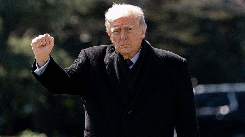 US President Donald Trump pumps his fist as he walks to depart on Marine One from the South Lawn of the White House. - AP