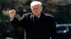 AP : US President Donald Trump pumps his fist as he walks to depart on Marine One from the South Lawn of the White House.