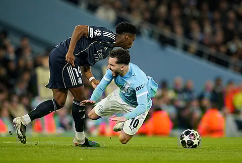 Real Madrid's Aurelien Tchouameni fouls Manchester City's Rayan Cherki during the Champions League round of 16 second leg soccer match between Manchester City and Real Madrid in Manchester.