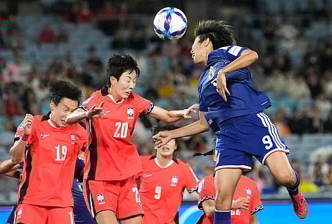 Japan's Riko Ueki, right, heads the ball during the Women's Asian Cup semifinal soccer match between Japan and South Korea in Sydney.