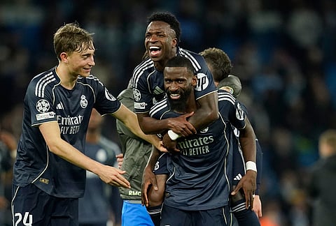 Real Madrid's Vinicius Junior jumps on Real Madrid's Antonio Ruediger after winning the Champions League round of 16 second leg soccer match between Manchester City and Real Madrid in Manchester.