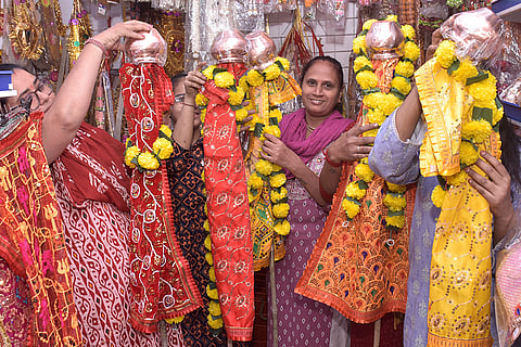 Women purchase ready-made 'Gudhi' at a shop ahead of the 'Gudhi Padwa' festival, in Surat, Gujarat.