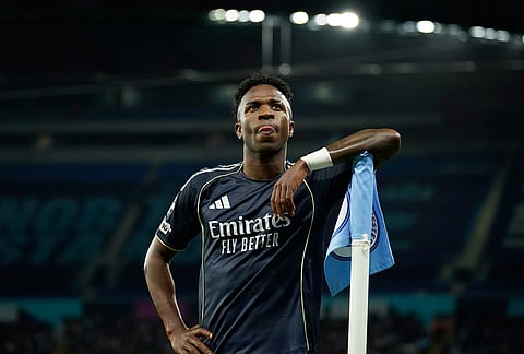 Real Madrid's scorer Vinicius Junior reacts at the corner flag after scoring the opening goal from the penalty spot during the Champions League round of 16 second leg soccer match between Manchester City and Real Madrid in Manchester.