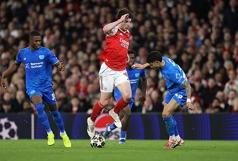Arsenal's Declan Rice, center, and Leverkusen's Exequiel Palacios, right, challenge for the ball during the second leg of the Champions League round of 16 soccer match between Arsenal and Bayer Leverkusen, in London.
