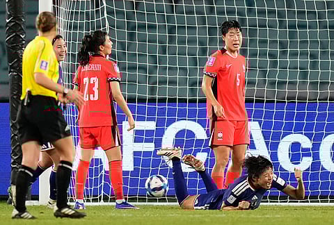 Japan's Saki Kumagai, on ground, celebrates after scoring her team's third goal during the Women's Asian Cup semifinal soccer match between Japan and South Korea in Sydney.