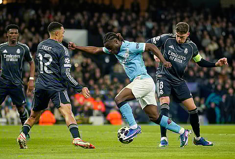 Manchester City's Jeremy Doku, Real Madrid's Trent Alexander-Arnold, left, and Real Madrid's Federico Valverde, right, challenge for the ball during the Champions League round of 16 second leg soccer match between Manchester City and Real Madrid in Manchester.
