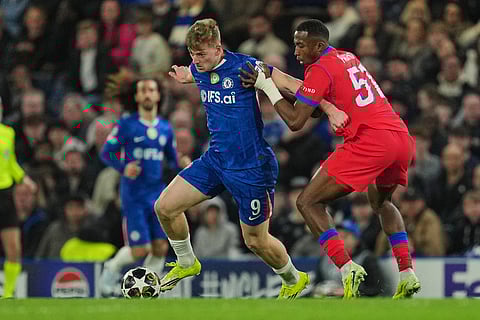 PSG's Willian Pacho, right, challenges for the ball with Chelsea's Liam Delap during the Champions League soccer match between Chelsea and Paris Saint-Germain in London, England.