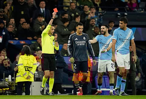 Referee Clement Turpin shows a red card for Manchester City's Bernardo Silva during the Champions League round of 16 second leg soccer match between Manchester City and Real Madrid in Manchester.