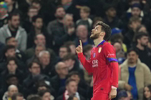 PSG's Khvicha Kvaratskhelia celebrates after scoring his side's opening goal during the Champions League soccer match between Chelsea and Paris Saint-Germain in London, England.