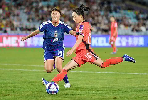 South Korea's Jang See-gi looks to get the ball past Japan's Momoko Tanikawa, left, during the Women's Asian Cup semifinal soccer match between Japan and South Korea in Sydney.