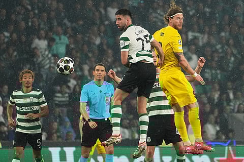 Sporting's Goncalo Inacio, center, is challenged by Glimt's Kasper Hogh during a Champions League round of 16 second leg soccer match between Sporting CP and Bodo Glimt in Lisbon, Portugal.