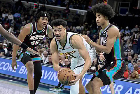 Denver Nuggets forward Spencer Jones (21) handles the ball between Memphis Grizzlies forwards Jaylen Wells, right, and GG Jackson II (45) in the second half of an NBA basketball game in Memphis, Tennessee.